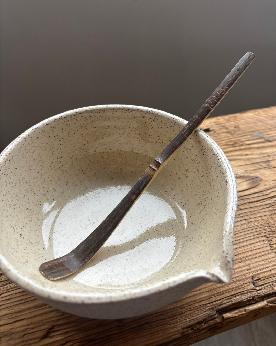 Nagi Matcha Bambo Spoon in a ceramic handmade bowl. The Nagi Matcha spoon  is handmade from sustainable dark bamboo