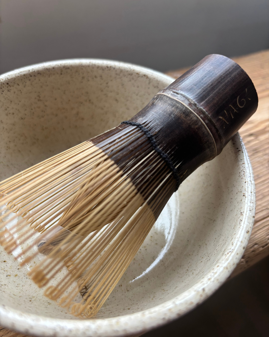 Nagi Matcha's Traditional bamboo whisk handmade from dark bamboo engraved with Nagi logo