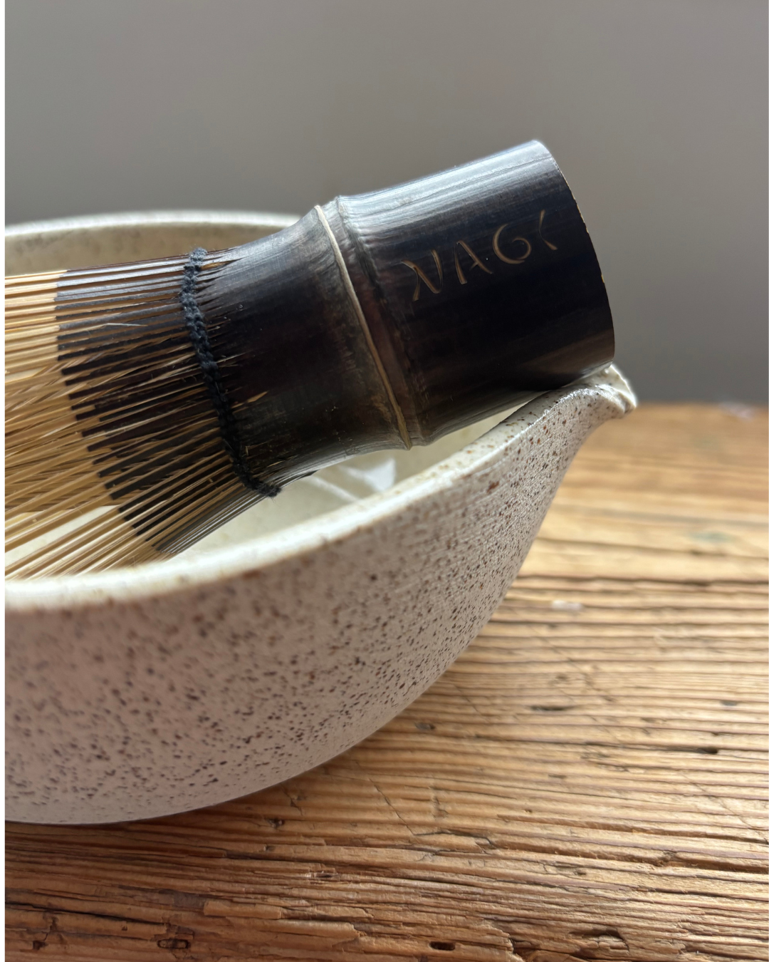 Nagi Matcha's Traditional bamboo whisk handmade from dark bamboo engraved with Nagi logo